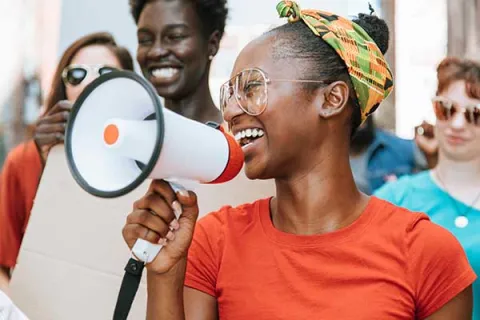 smiling woman with megaphone with group behind her