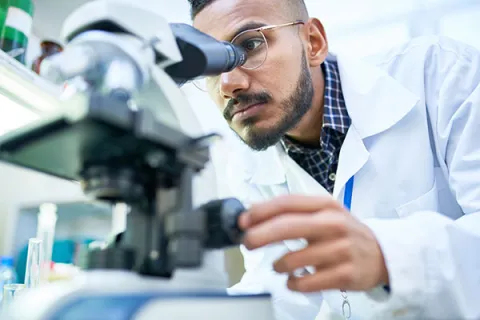 scientist looking at microscope